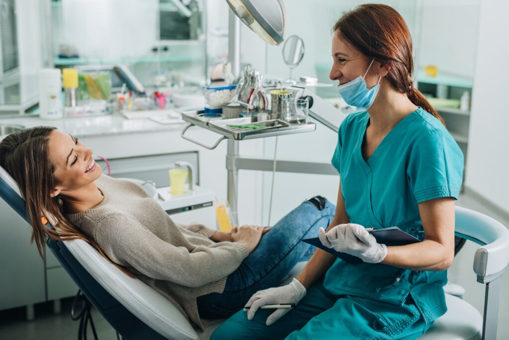 woman in the dentist chair smiling at the dentist sitting next to her