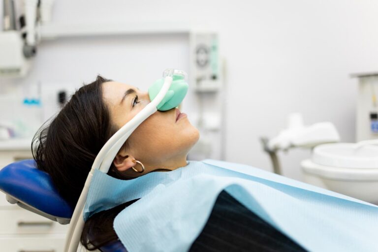 An adult woman sits in a dentist's office wearing a nasal mask to inhale nitrous oxide. Dentist fear concept. Feeling of relaxation with laughing gas. Visit a dentist with relaxation.